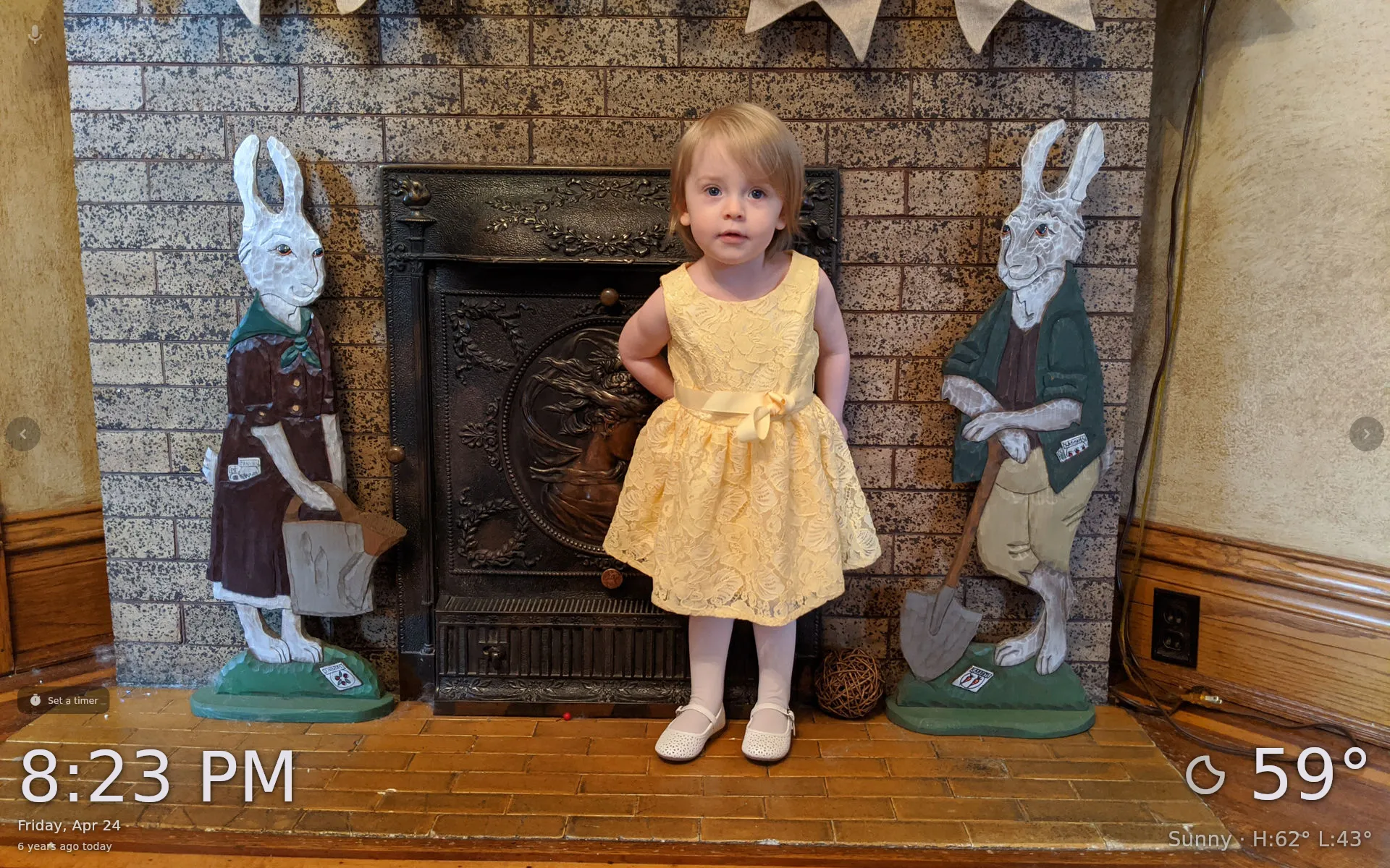 Hearth display showing 8:23 PM and 59° sunny weather over a photo of a child by a stone fireplace